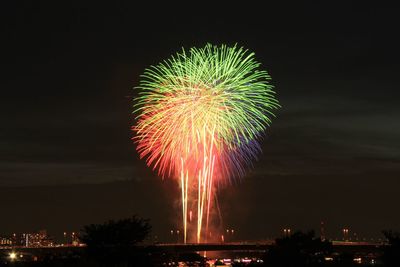 Firework display against sky at adachi