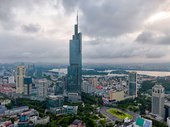 High angle view of buildings in city against cloudy sky