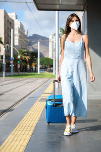 Rear view of woman walking on road in city