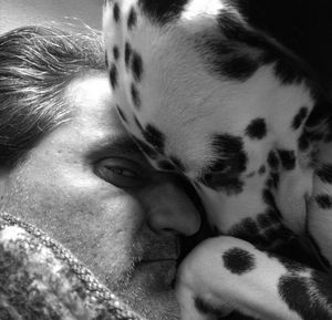 Close-up high angle portrait of man with dog resting at home
