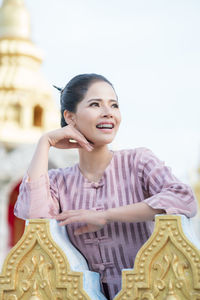 Smiling woman standing by railing