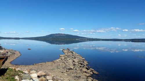 Scenic view of lake against clear blue sky