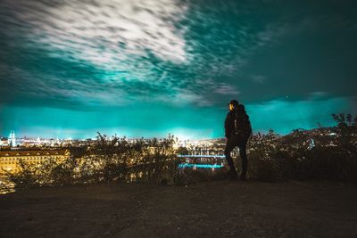 Rear view of man standing by sea against sky