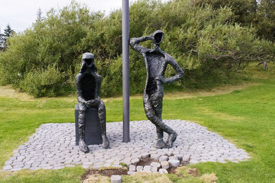 Statue on field against sky