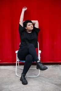 Full length of a young woman sitting on seat