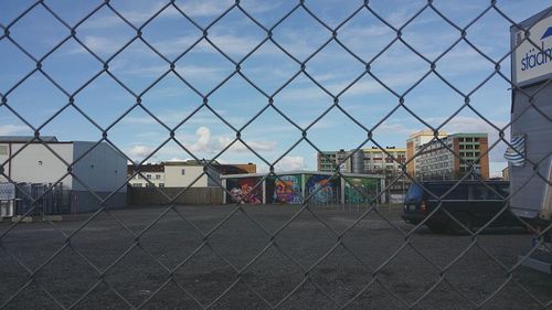 Chainlink fence against cloudy sky