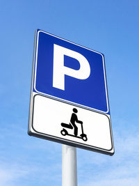 Low angle view of road sign against blue sky