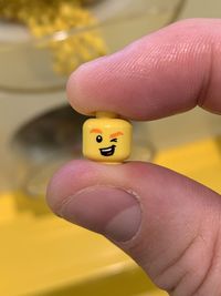 Close-up of hand holding yellow ring