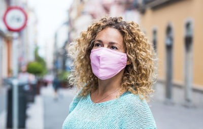 Close-up of woman wearing mask looking away in city