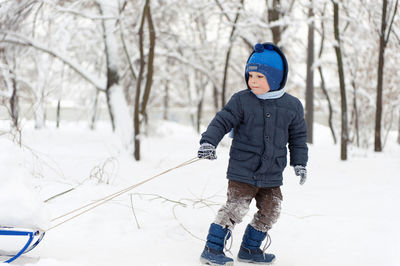 Rear view of boy in snow during winter