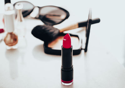 Lipstick in front of make-up product on table