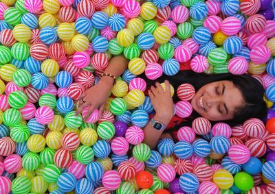 Directly above shot of woman lying in ball pool