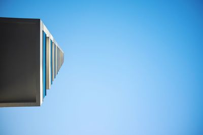 Low angle view of modern building against clear blue sky