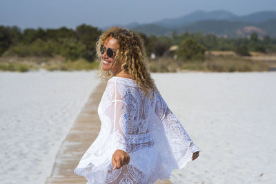 Portrait of young woman standing at beach