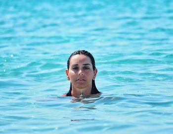 Portrait of young woman swimming in pool