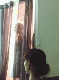 Woman looking through window