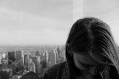 Portrait of woman looking at cityscape against sky