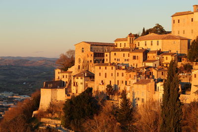 Buildings in town against clear sky