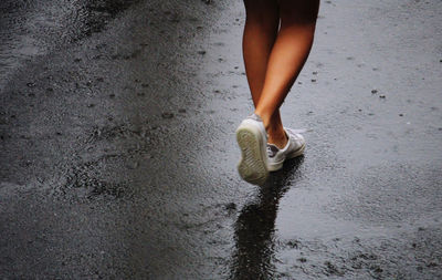 Low section of woman walking on wet floor