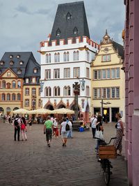 People walking on street amidst buildings in city