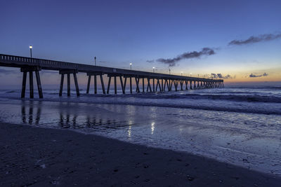 Pier over sea against sky during sunset