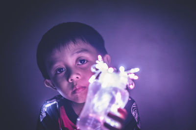 Close-up of boy with fairy lights
