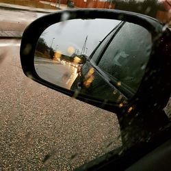 Reflection of car on wet side-view mirror