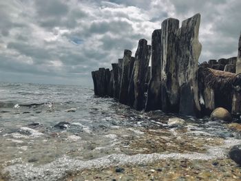 Panoramic shot of rocks on beach against sky
