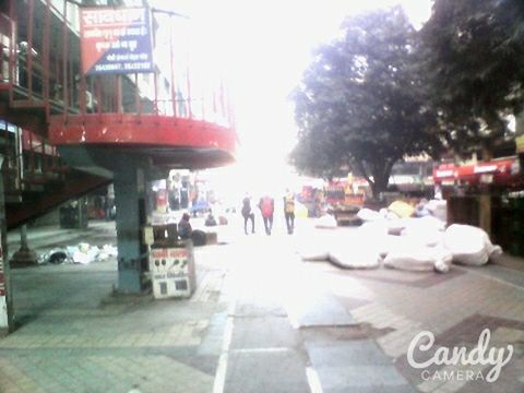 city, street, building exterior, built structure, architecture, transportation, incidental people, car, city life, sunlight, road, city street, outdoors, text, mode of transport, tree, land vehicle, communication, large group of people