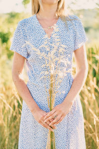 Midsection of woman standing against plants