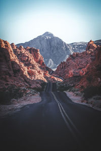 Road amidst mountains against clear sky