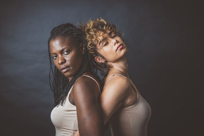 Portrait of young women against black background