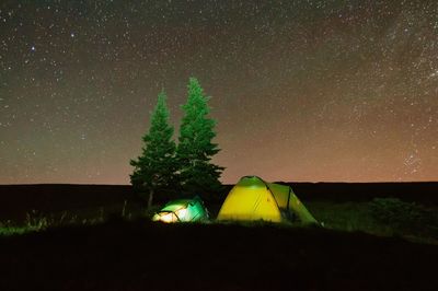 Scenic view of illuminated field against sky at night