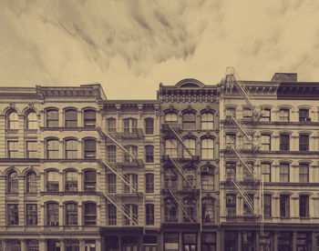 Low angle view of buildings against cloudy sky