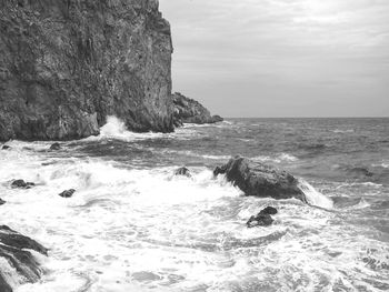 Scenic view of rocks in sea against sky