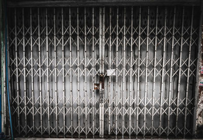 Close-up of closed gate against fence