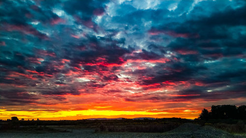 Scenic view of dramatic sky over silhouette landscape