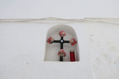 Low angle view of cross on window of building