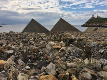 Panoramic view of rocks on shore against sky