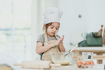 Girl eating food on table at home