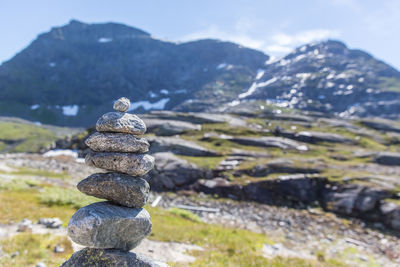 Stack of stones on rock against sky