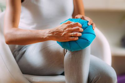 Knee pain treatment. woman holding an ice bag pack on her painful knee