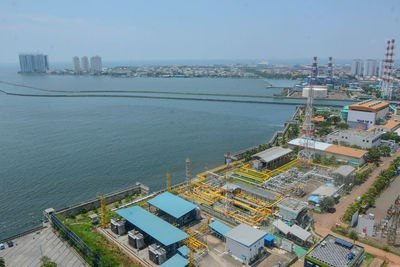 High angle view of city by sea against sky