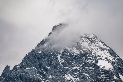 Low angle view of snowcapped mountain against sky