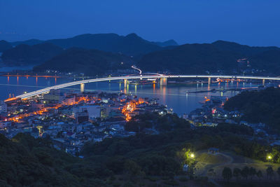 Illuminated bridge over river at night