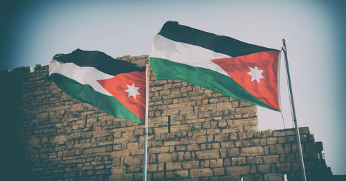 Low angle view of flag against built structure