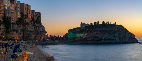 Panoramic view of sea and buildings against sky during sunset