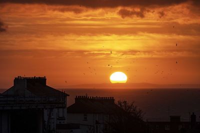 Silhouette buildings against sky during sunset