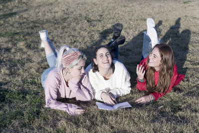 Smiling young women lying on grassy field at park