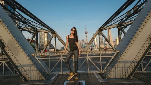 Low angle view of woman standing on bridge